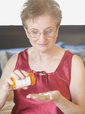 Elderly woman pouring antibiotic in her palm
