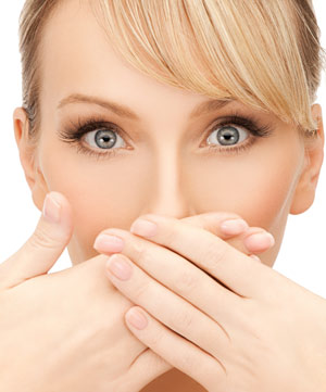 Woman covering mouth due to bad breath