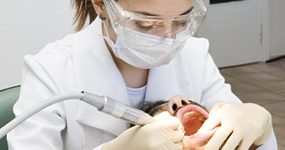 Dental patient having dental cleaning using ultrasonic scaler