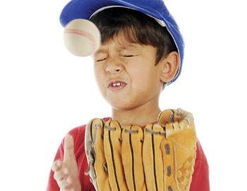 Kid about to be hit with a baseball ball in the face