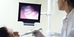 Dental patient undergoing dental exam using intra-oral camera