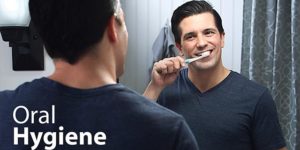 Man Brushing his teeth in front of a mirror