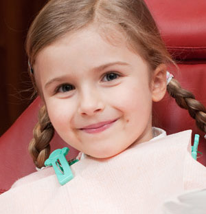 Smiling young girl on dental chair