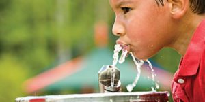 Child drinking water in water fountain