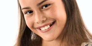 Young girl with missing teeth smiling
